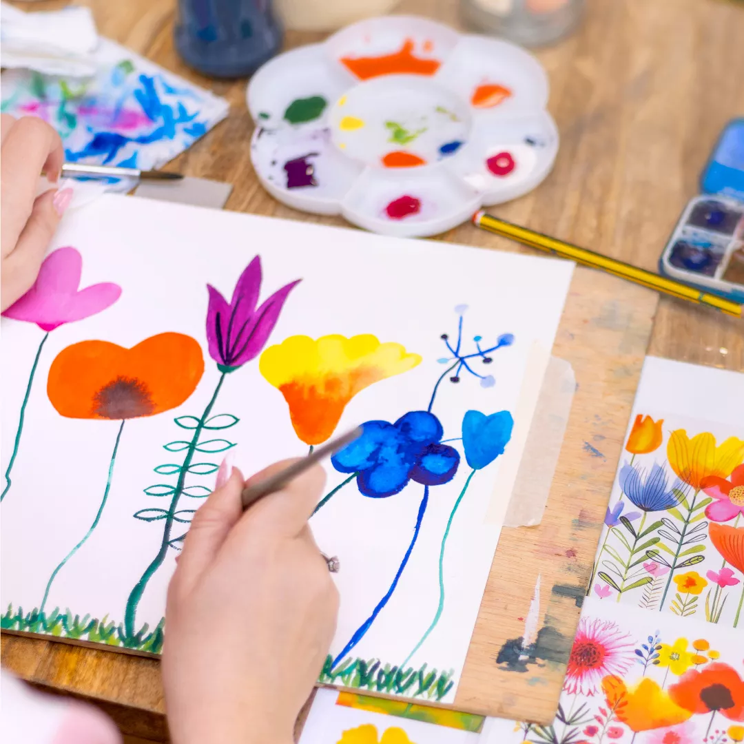 Pessoa pintando flores vibrantes em uma tela
